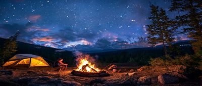 探花社区户外露营直播，主播在山间营地夜晚升起篝火，星空背景壮阔迷人